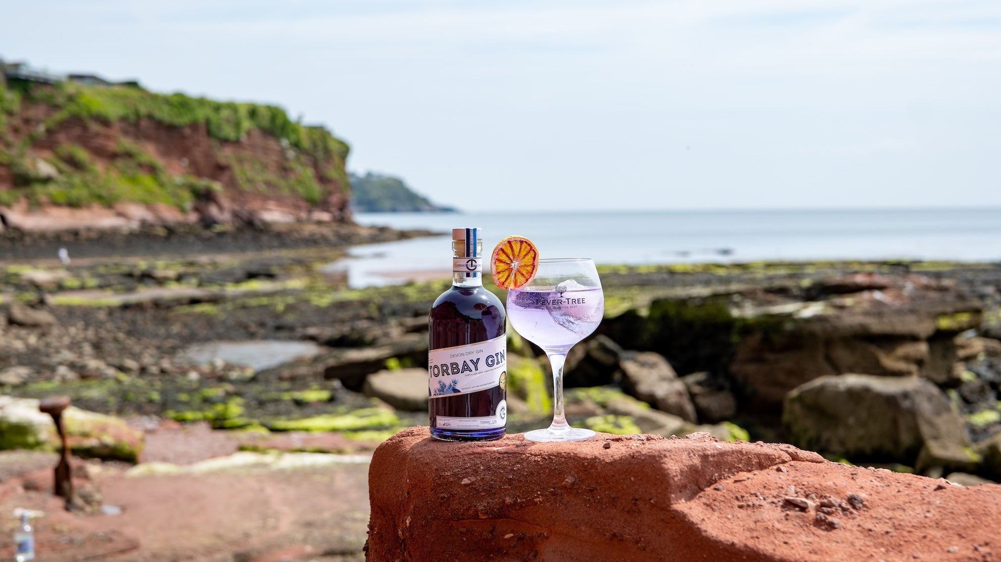 torbay gin's colour changing gin on a beach in torbay